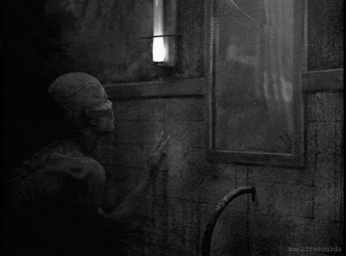 Гиф с костлявым монстром заглядывающим в пыльное зеркало