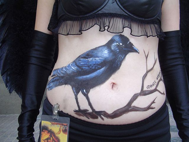 Черный ворон на довольно приличном женском пузе, бодиарт, рисунок на теле, фото бодиарта