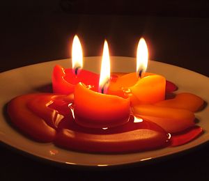 фото 3-х горящих оранжевых свечей для благополучия в доме