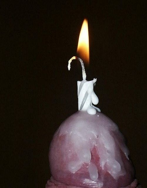 горящая свеча вставлена мужчиной в свой член, расплавленный воск заливает головку пениса. фото мужского члена