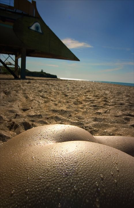 песчаные дюны. голая женская попа на фоне песка. прикол с эротикой