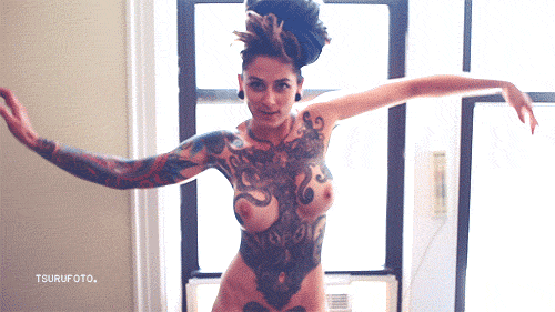 волна. полностью татуированная женщина пытается изобразить волнообразные движения руками. секс гиф