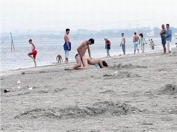 кто кого - секс на пляже. парочка трахается в позе раком посреди городского пляжа. прикольный сексуальный комплекс