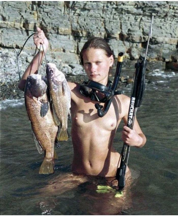 девушка с маленькими сиськами и подводным ружьем демрнстрирует свои трофеи , забавная эротическая картинка, фото прикол