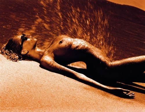 брызги пустыни. голая женщина лежит на песке. фото прикол эротический