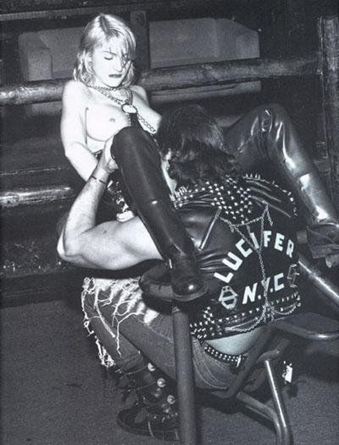 байкер сидя перед расставившей ноги Мадонной делает ей куннилингус, черно-белое фото