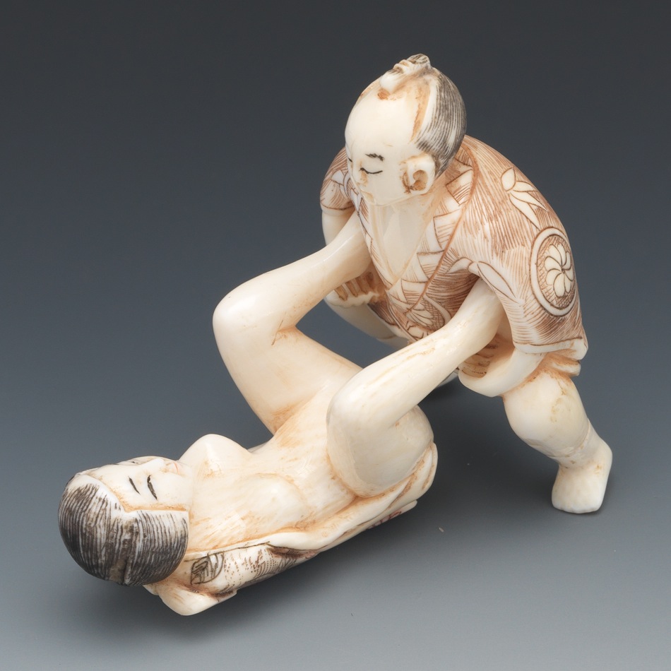 японская костяная фигурка изображающая введение члена лежащей на спине голой женщине