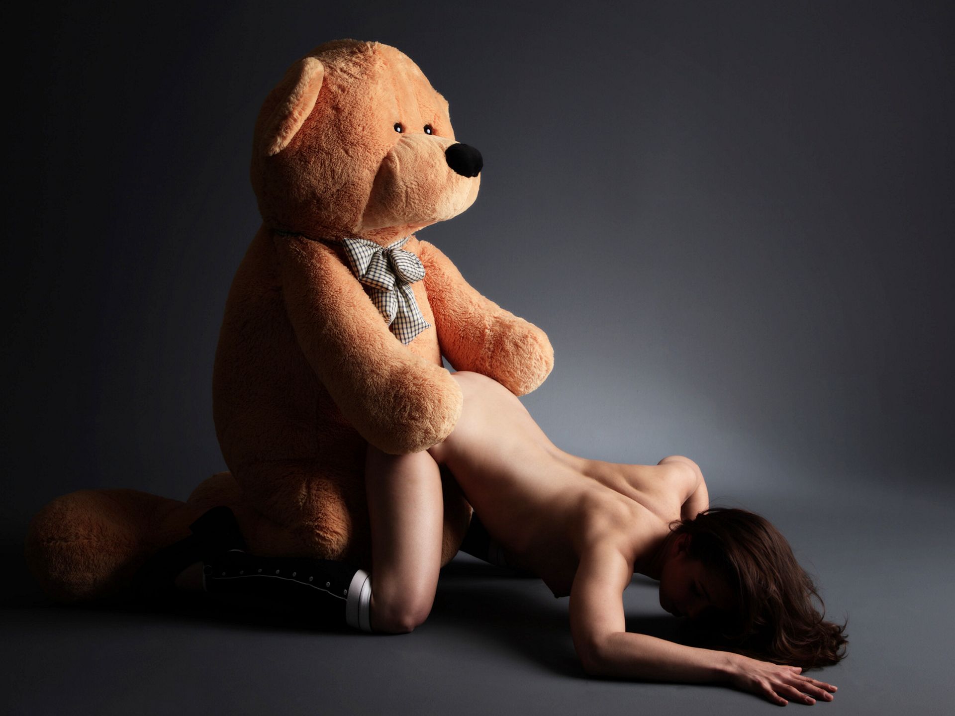 огромный плюшевый медведь трахает стоящую в позе для собачьего секса голую девушку