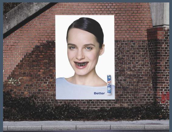 кирпичная стена отлично гармонирует с лицом девушки, вызывая почти физическое желание воспользоваться рекламируемой здесь зубной пастой и почистить девушке зубы, смешная реклама, креативная реклама, рекламный прикол