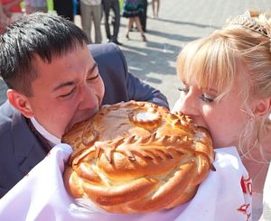 фото жениха и невесты кусающих свадебный хлеб