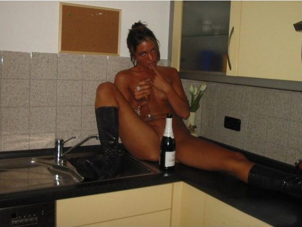 голая пьяная девушка в сапогах забралась на кухне на панель с мойкой потягивая шампанское , забавная эротическая картинка, фото прикол