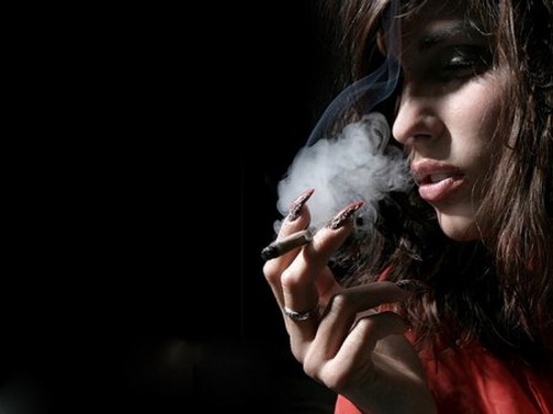 дым. сигара в руках с женщины с жуткими когтями на пальцах.  красивое женское тело