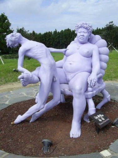 не уйдешь. скульптура изображает худенького мужчину попавшего в лапы к голой толстой женщине. бесплатная прикольная картинка