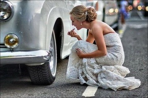 зеркальце. женщина подкрашивает губы глядя в зеркальные колпаки своего автомобиля