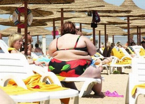 шезлонг. удивительно толстая девушка в купальнике сидит на трещащем шезлонге