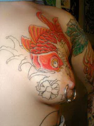 золотая рыбка на правой груди девушки, женская татуировка фото
